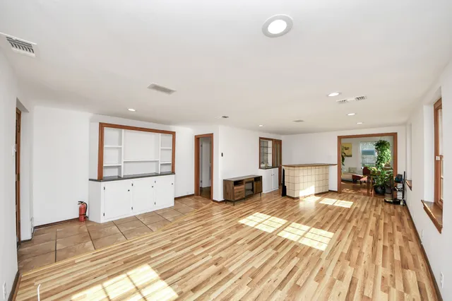 a spacious bedroom with a bed and wooden floor