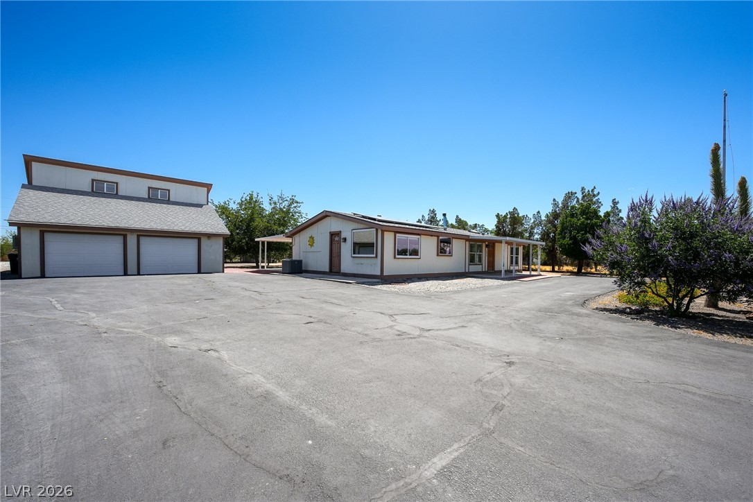 1831 West Horn Road Pahrump, NV 89048 - Photo 32 of 59 Ample paved driveway leads to a welcoming residence with an accompanying two-car garage.