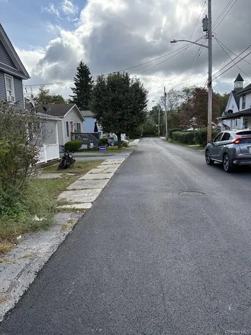 a view of a city street with a car parked on the road