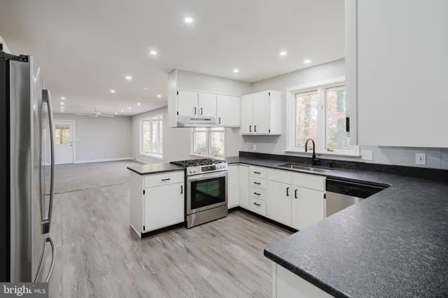 a kitchen with granite countertop white cabinets and appliances