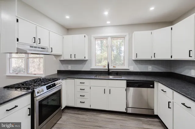 a kitchen with stainless steel appliances granite countertop a stove a sink and a refrigerator