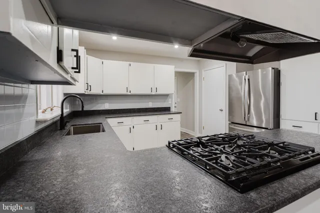 a kitchen with stainless steel appliances granite countertop a stove a sink and a refrigerator