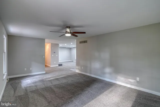 a view of a livingroom with a ceiling fan and window