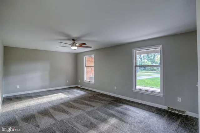 a view of a room with a ceiling fan and window