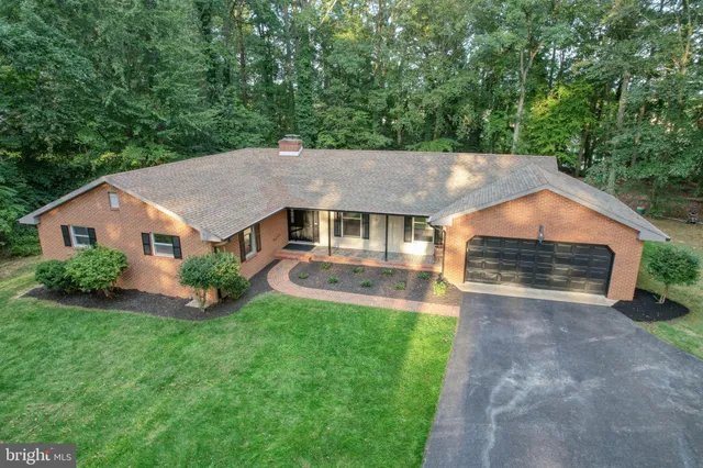 a view of a house with a yard and large tree