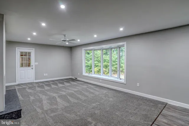 an empty room with windows and fireplace