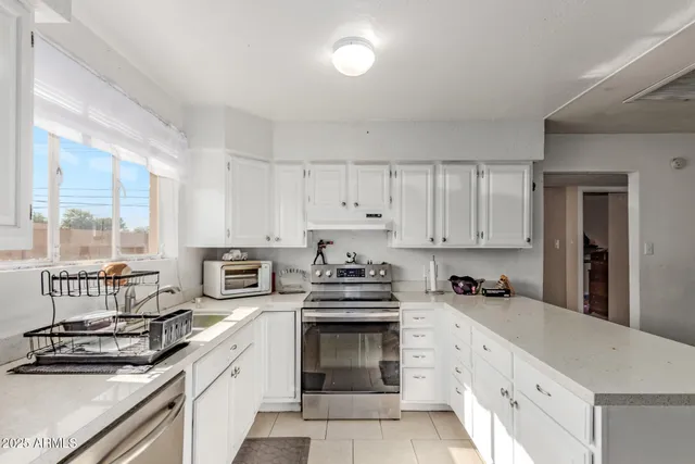 a kitchen with granite countertop a stove sink and cabinets