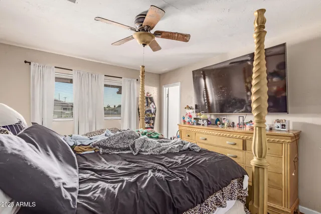 a bedroom with a large bed and a flat tv screen