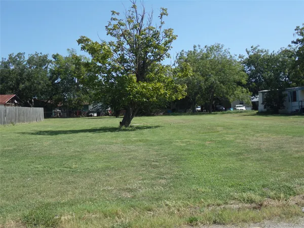 a view of a field with trees in the background