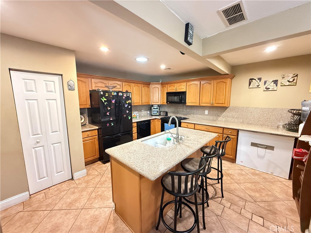 1014 North Daisy Avenue Santa Ana, CA 92703 - Photo 10 of 27 a kitchen with stainless steel appliances kitchen island granite countertop a refrigerator a stove top oven and a dining table with wooden floor