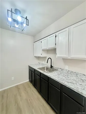 a kitchen with granite countertop a sink and cabinets