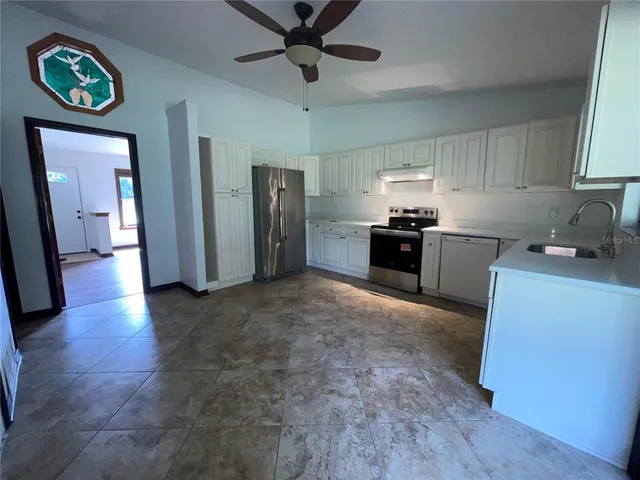 a kitchen with stainless steel appliances granite countertop a refrigerator a stove top oven a sink and dishwasher