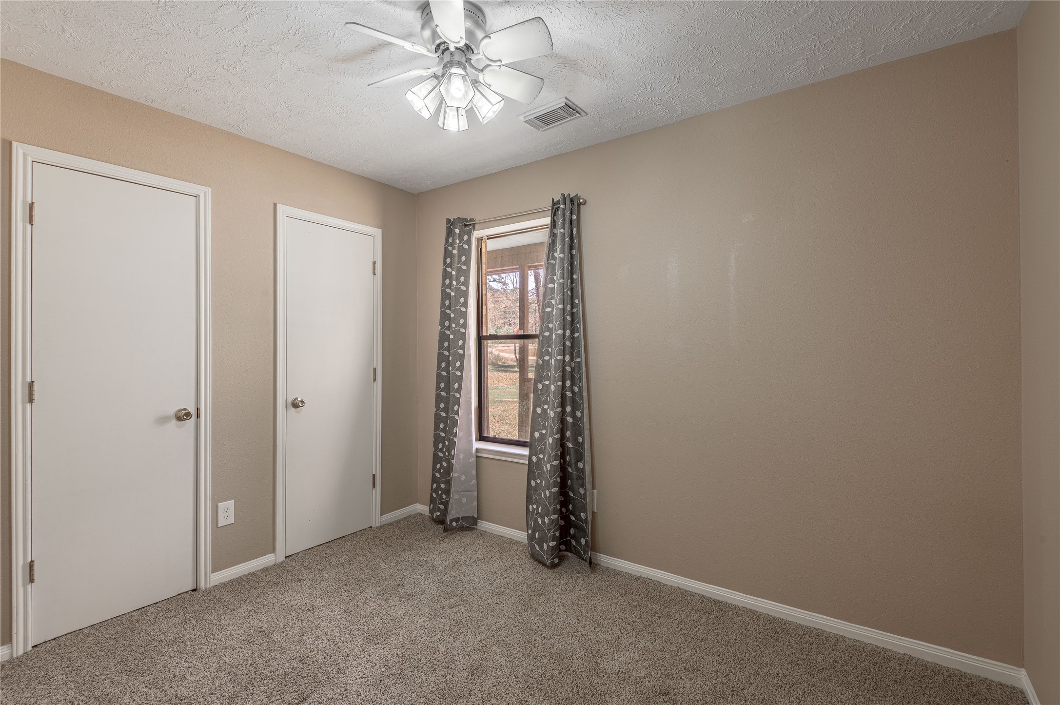 2 Brown Road Huntsville, TX 77320 - Photo 18 of 28 an empty room with a chandelier fan and windows