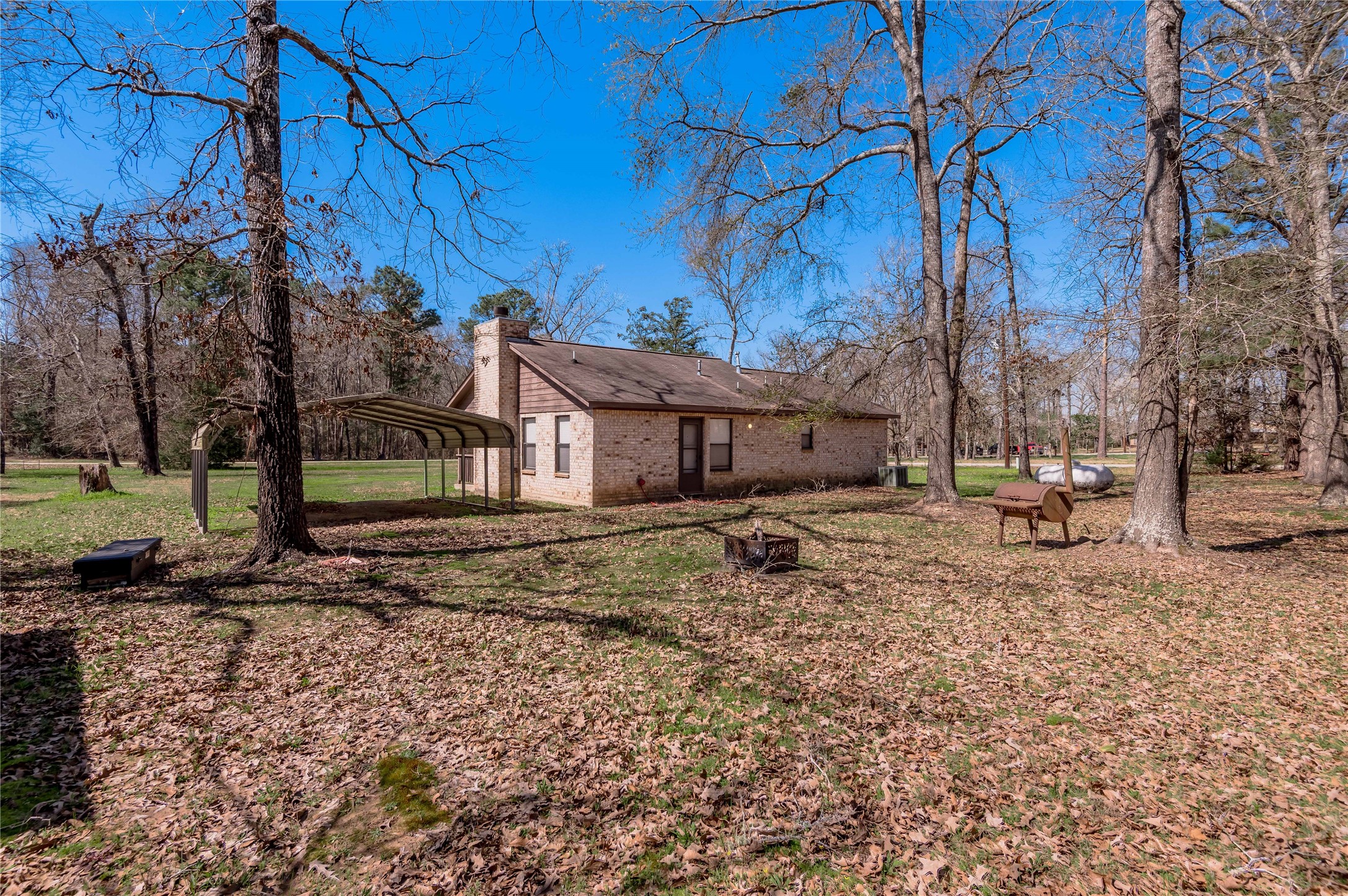 2 Brown Road Huntsville, TX 77320 - Photo 24 of 28 a view of a house with a yard covered in the forest