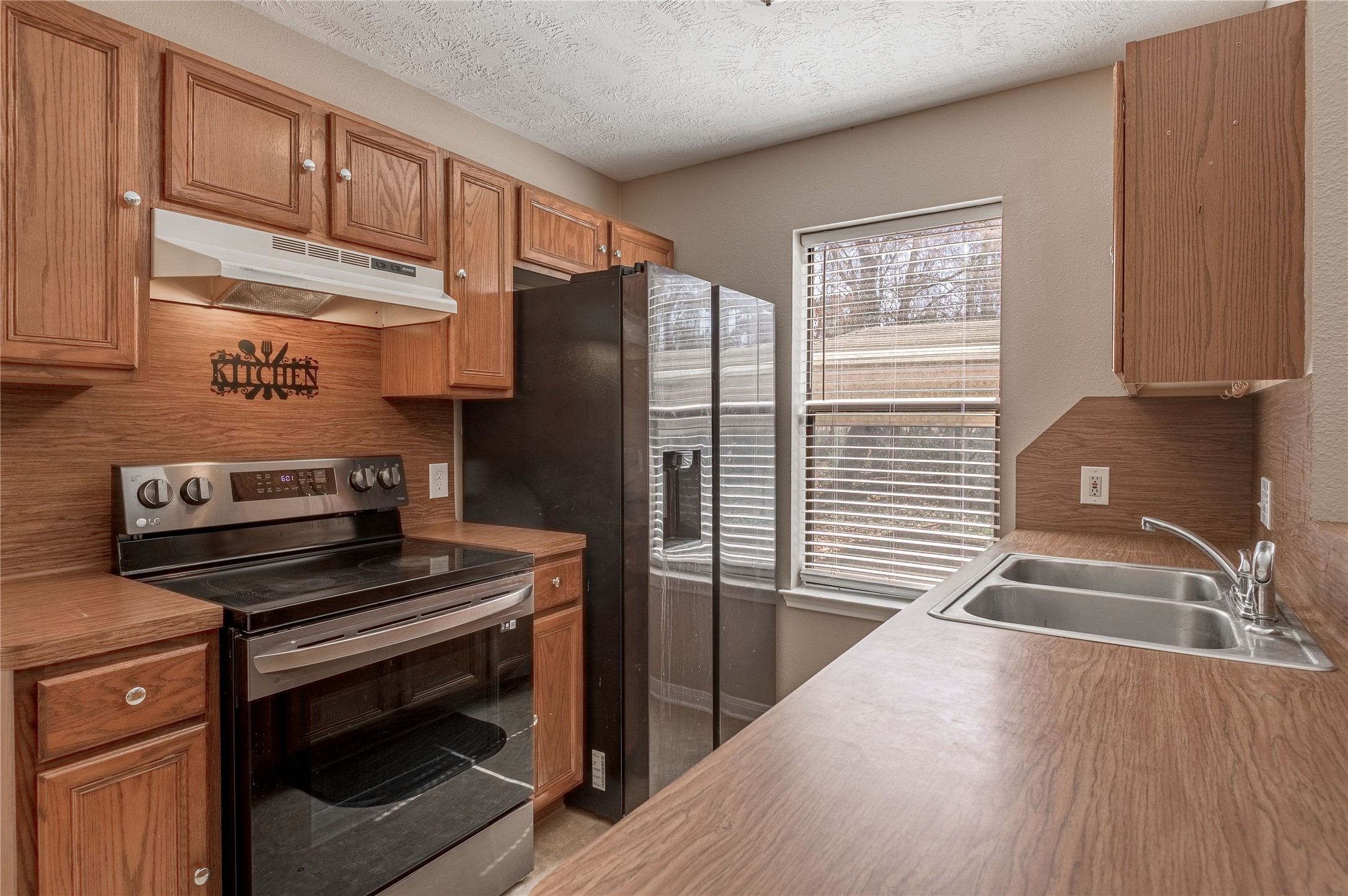 2 Brown Road Huntsville, TX 77320 - Photo 5 of 28 a kitchen with wooden cabinets and a stove top oven