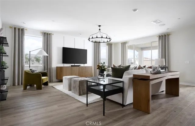 a living room with furniture a flat screen tv and wooden floor