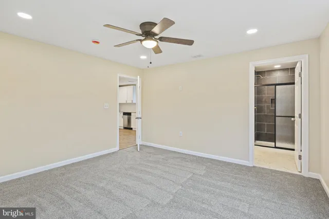 an empty room with closet and a chandelier fan