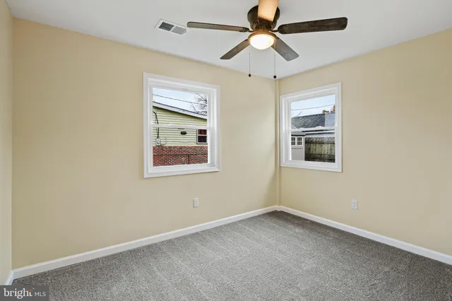 an empty room with a window and a fan
