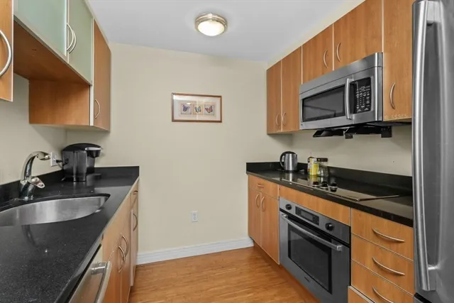 a kitchen with stainless steel appliances granite countertop a sink stove and microwave