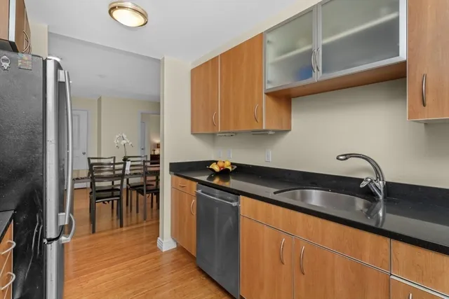 a kitchen with granite countertop a sink stove and refrigerator