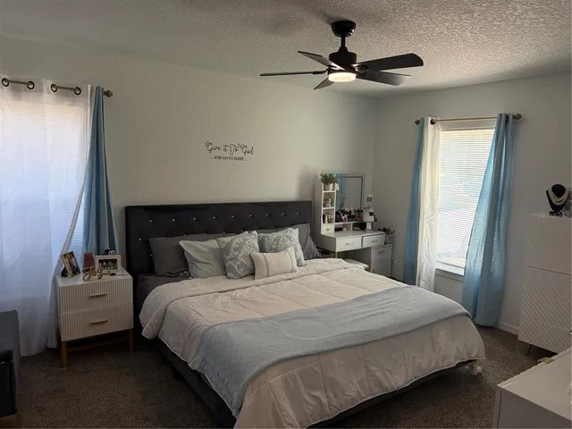 a bedroom with a bed and a ceiling fan