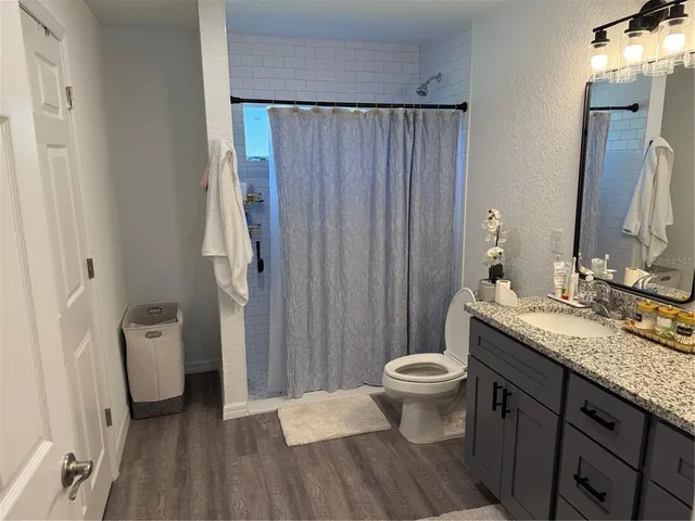 a bathroom with a granite countertop sink toilet and shower