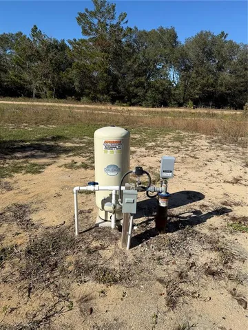 a view of a field with trees in the background