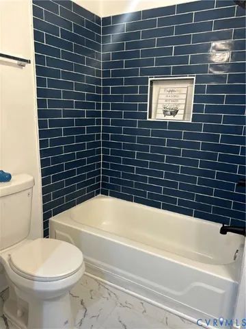 a bathroom with a toilet and a bath tub