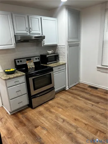 a kitchen with granite countertop a stove and a refrigerator