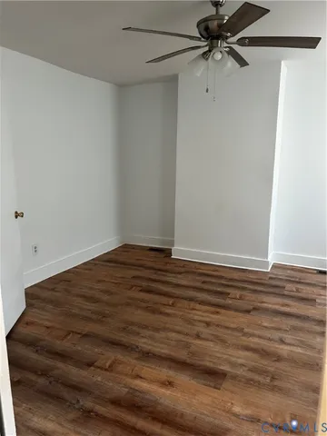 a view of a room with wooden floor and fan