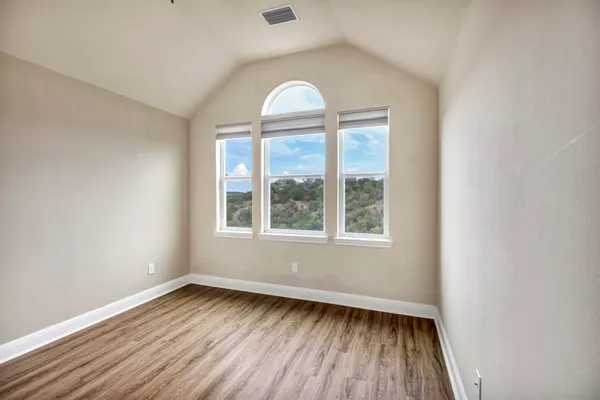 an empty room with wooden floor and a window