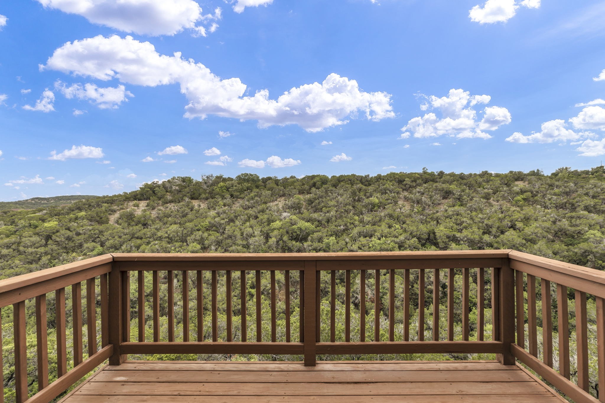 206 Sunrise Ridge Cove Austin, TX 78738 - Photo 2 of 38 a balcony with wooden floor in view