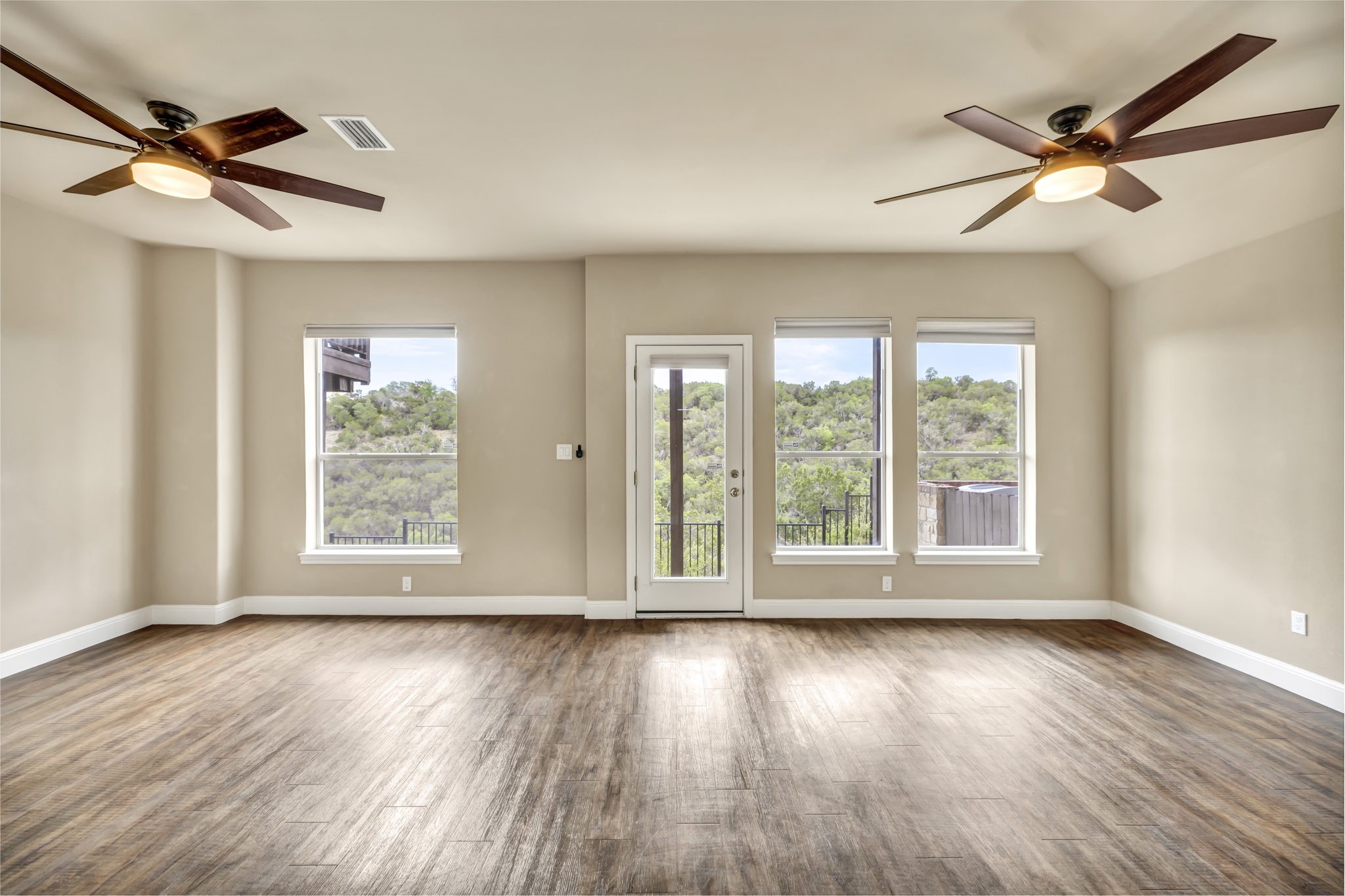 206 Sunrise Ridge Cove Austin, TX 78738 - Photo 22 of 38 a view of an empty room with wooden floor and a window