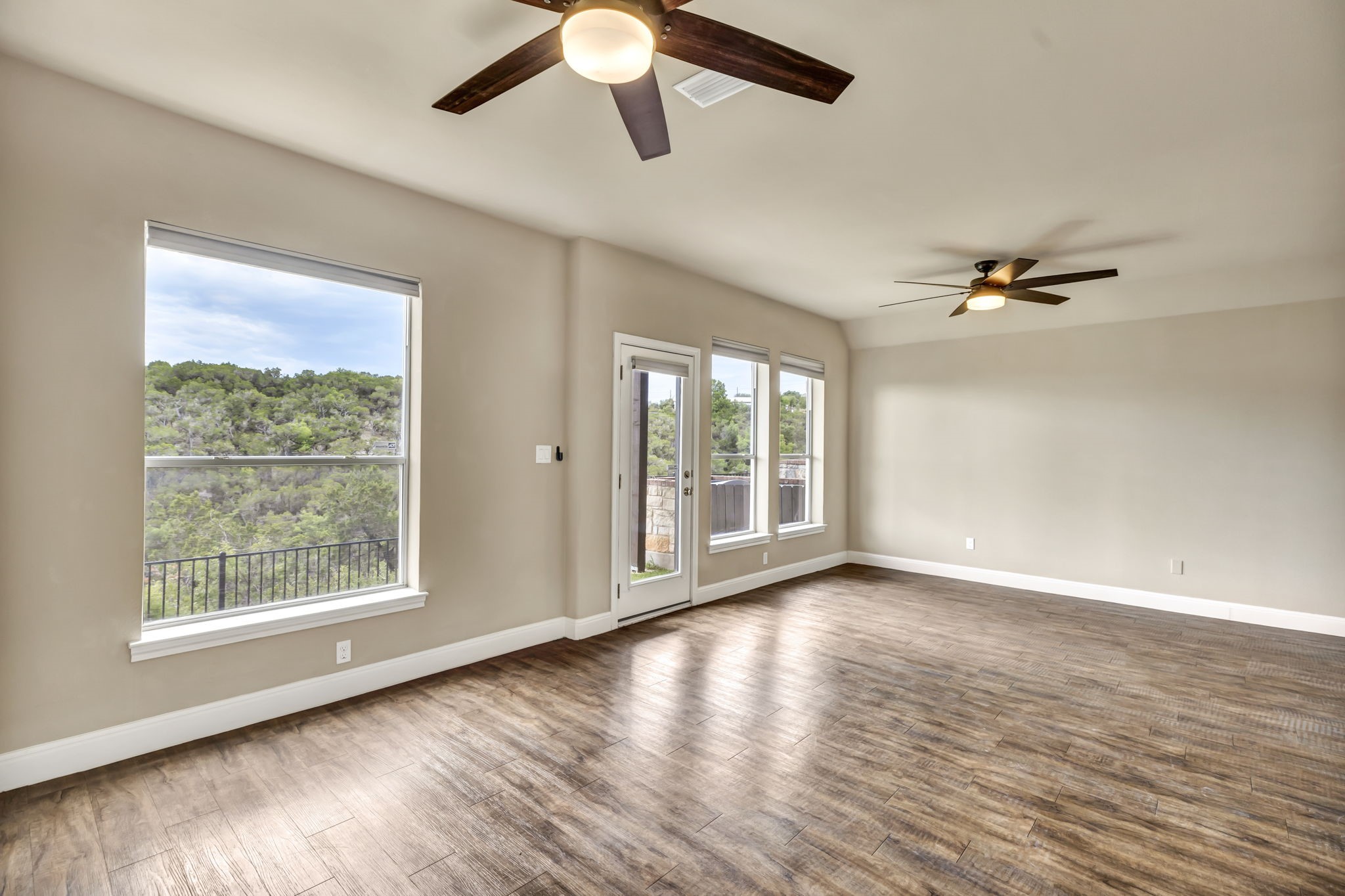 206 Sunrise Ridge Cove Austin, TX 78738 - Photo 26 of 38 a view of an empty room with wooden floor and a window