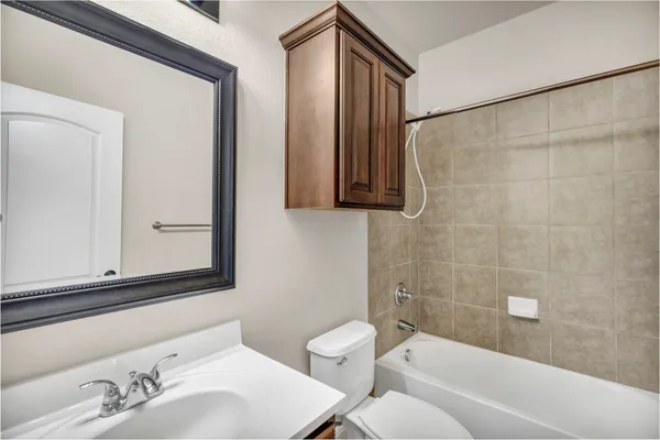 a bathroom with a bathtub a sink a mirror and a toilet