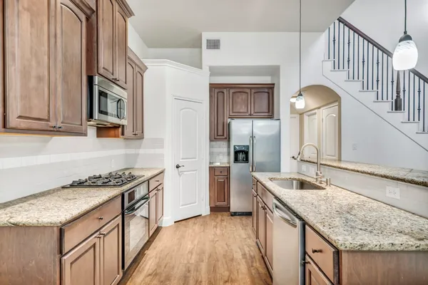 a kitchen with stainless steel appliances granite countertop a sink stove and refrigerator