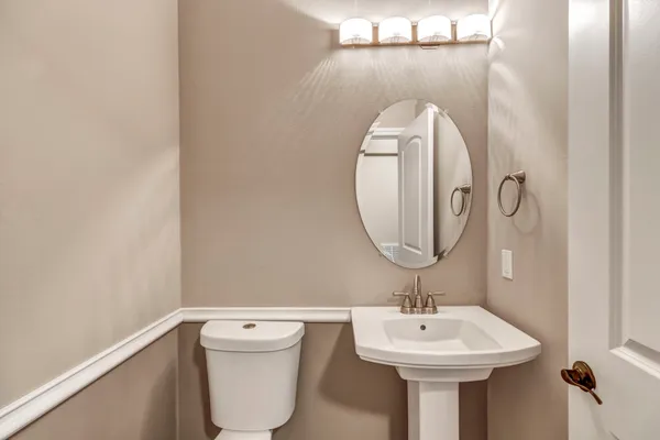 a bathroom with a sink mirror and toilet