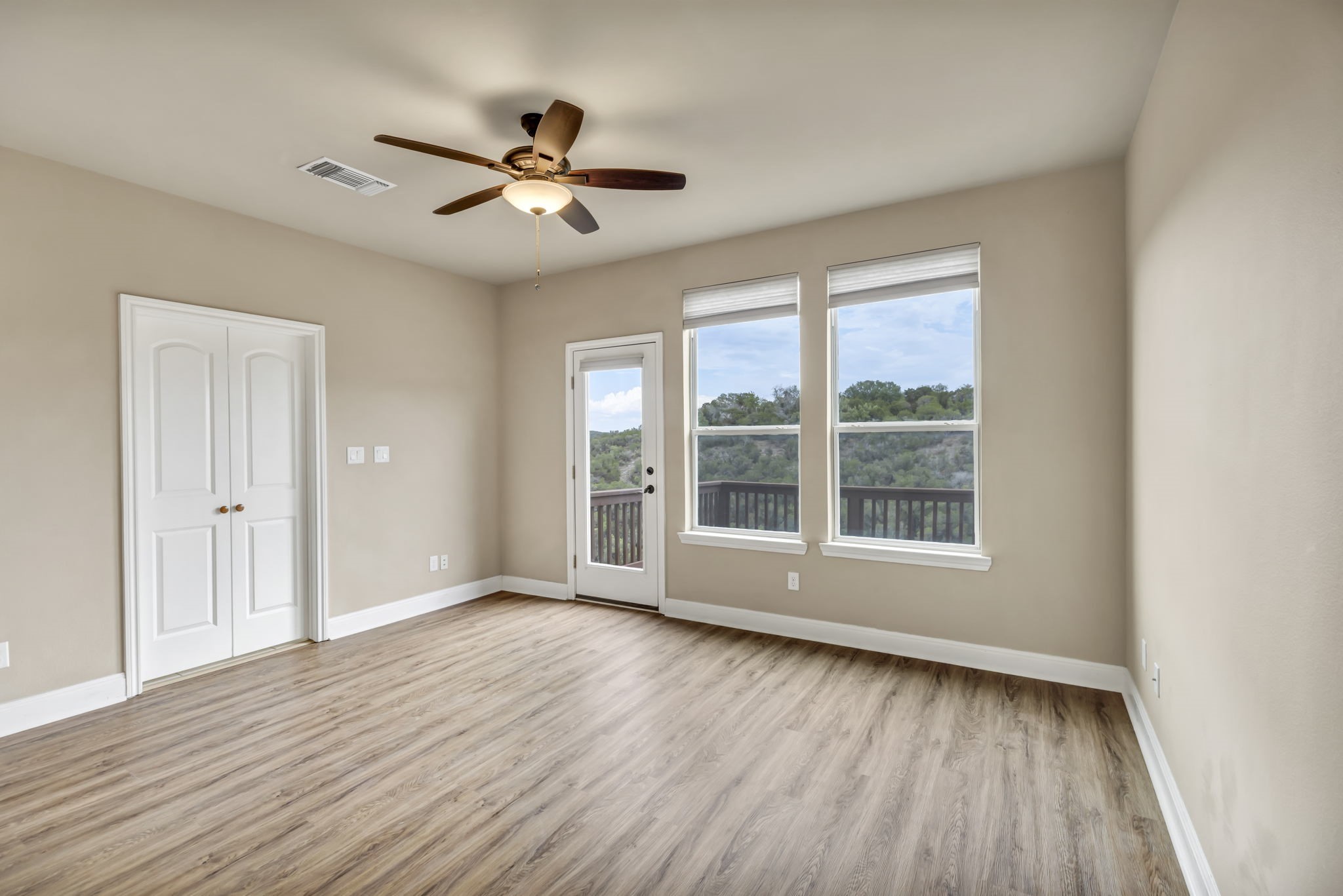206 Sunrise Ridge Cove Austin, TX 78738 - Photo 9 of 38 a view of an empty room with wooden floor and a window