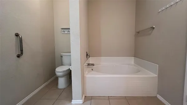 a white bath tub sitting next to a toilet