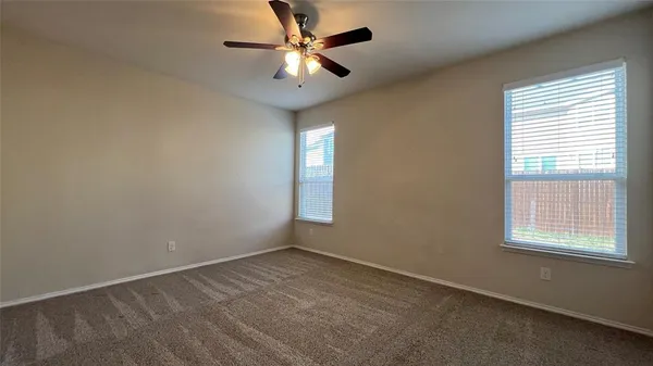 an empty room with a window and a fan