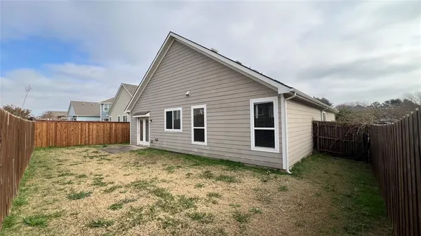 a view of a house with a small yard and wooden fence