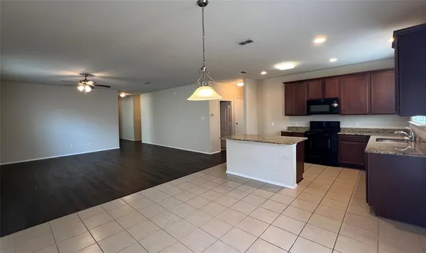 a kitchen with stainless steel appliances granite countertop a refrigerator a sink and a stove