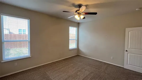 an empty room with a window and a chandelier fan
