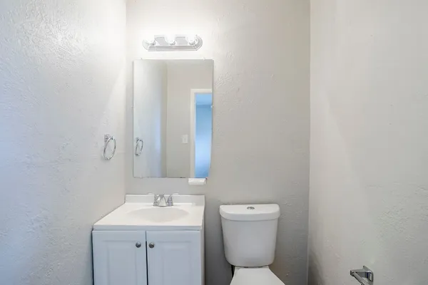 a bathroom with a toilet sink and mirror
