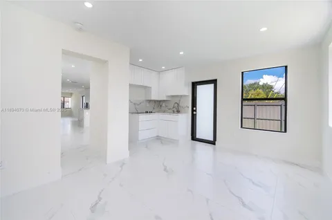 a view of kitchen with refrigerator and window