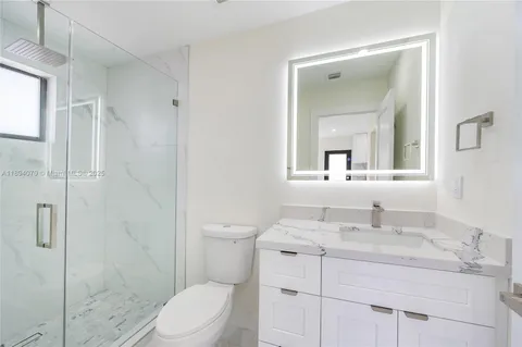 a bathroom with a sink toilet vanity and shower