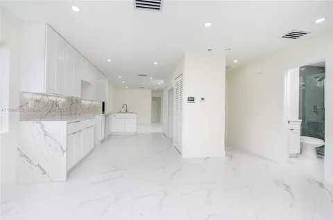 a view of kitchen with white cabinets and sink