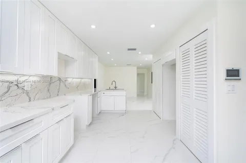 a large white kitchen with a sink
