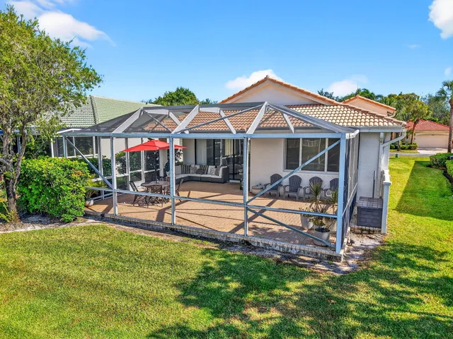 a view of a house with a big yard and large trees