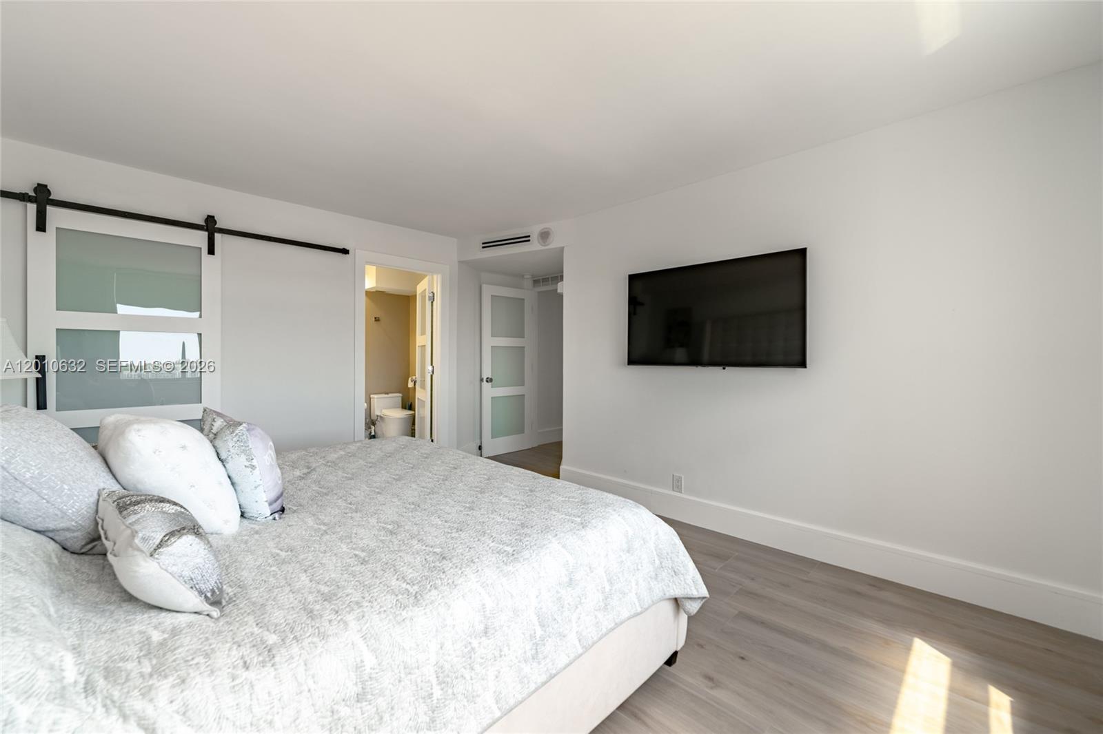 2639 North Riverside Drive, Unit 501 Pompano Beach, FL 33062 - Photo 16 of 39 a bedroom with a bed and a flat screen tv